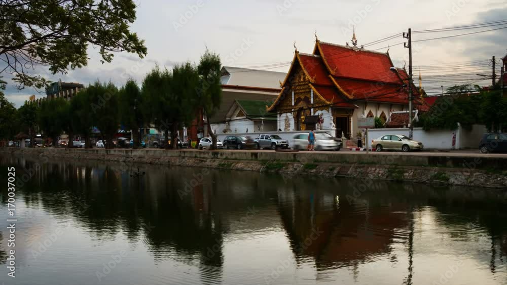Chiang Mai, Thailand. Lively street in popular touristic town Chiang Mai, Thailand. With historical buildings and water reflection. Time-lapse at sunset. Zoom in Chiang Mai, Thailand. Lively street in popular touristic town Chiang Mai, Thailand. With historical buildings and water reflection. Time-lapse at sunset. Zoom in