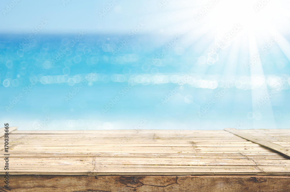 Blur tropical beach with bokeh sun light wave on empty old wood table abstract background. Blur tropical beach with bokeh sun light wave on empty old wood table abstract background.