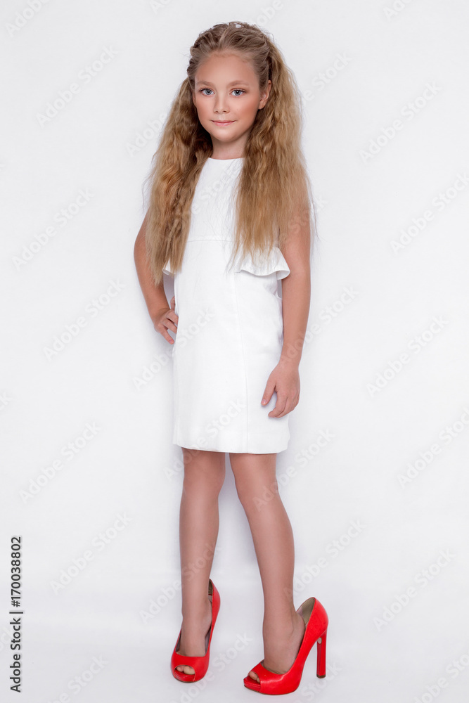 Pretty stunning little girl little princess, standing on a white ...