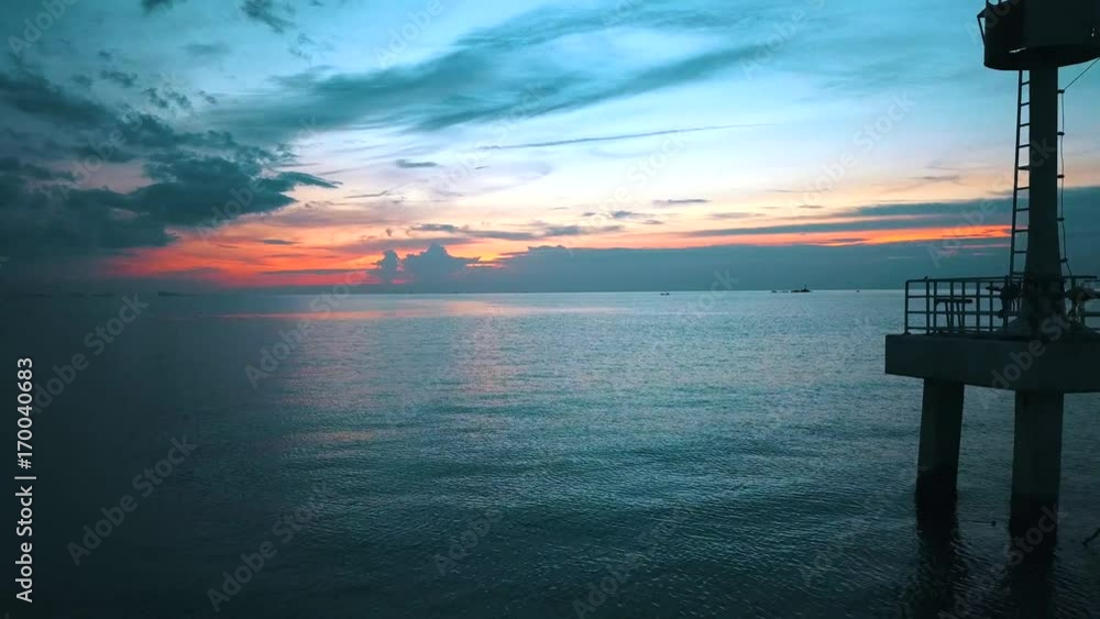 Drone flying around small lighthouse silhouette at twilight Drone flying around small lighthouse silhouette at twilight