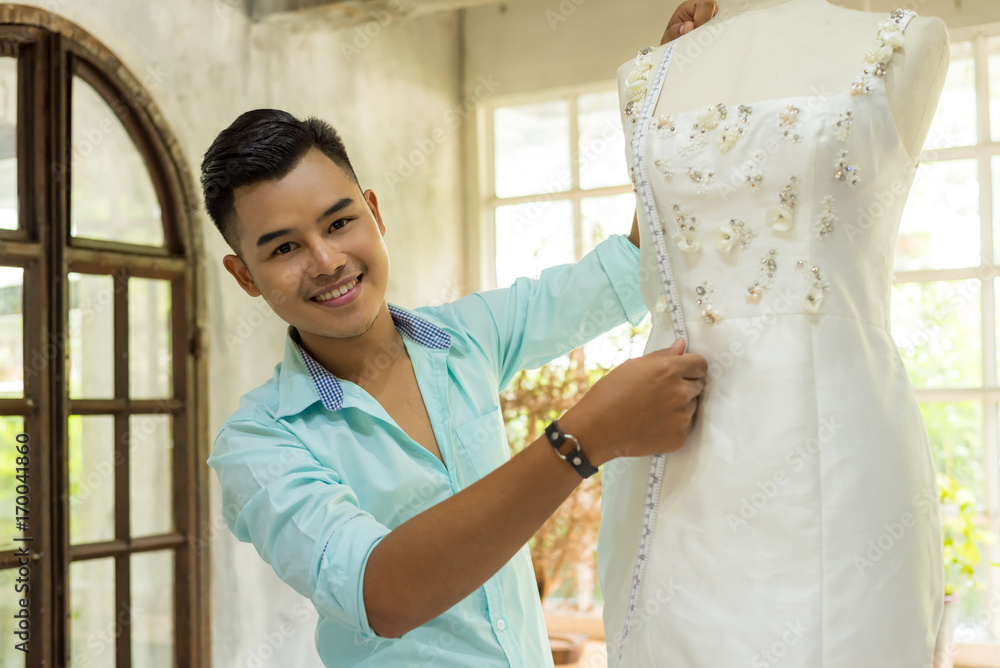 Young asian confident fashion designer clothes man working at studio. Happy work for successful Teamwork fashion designer concept Photos Adobe Stock