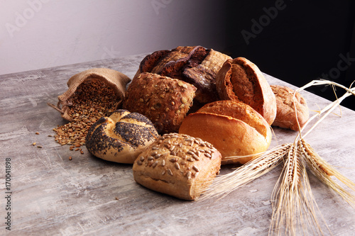 Different kinds of bread and bread rolls on board. Kitchen or bakery poster design.