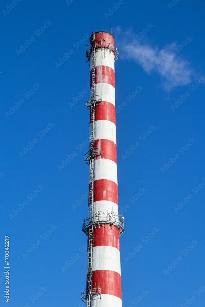 Red and white chimney against the blue sky Red and white chimney against the blue sky