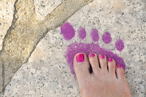 single pink footprint on the stone, human carbon footprint on nature concept, follow one's steps concept