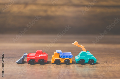 Toy construction machinery on wooden background