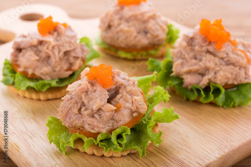 tuna salad with cracker on wooden background