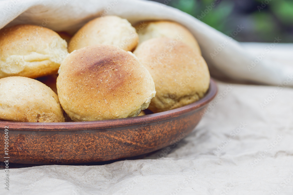 Homemade breads or bun In a clay plate on wood background. Homemade baking Homemade breads or bun In a clay plate on wood background. Homemade baking