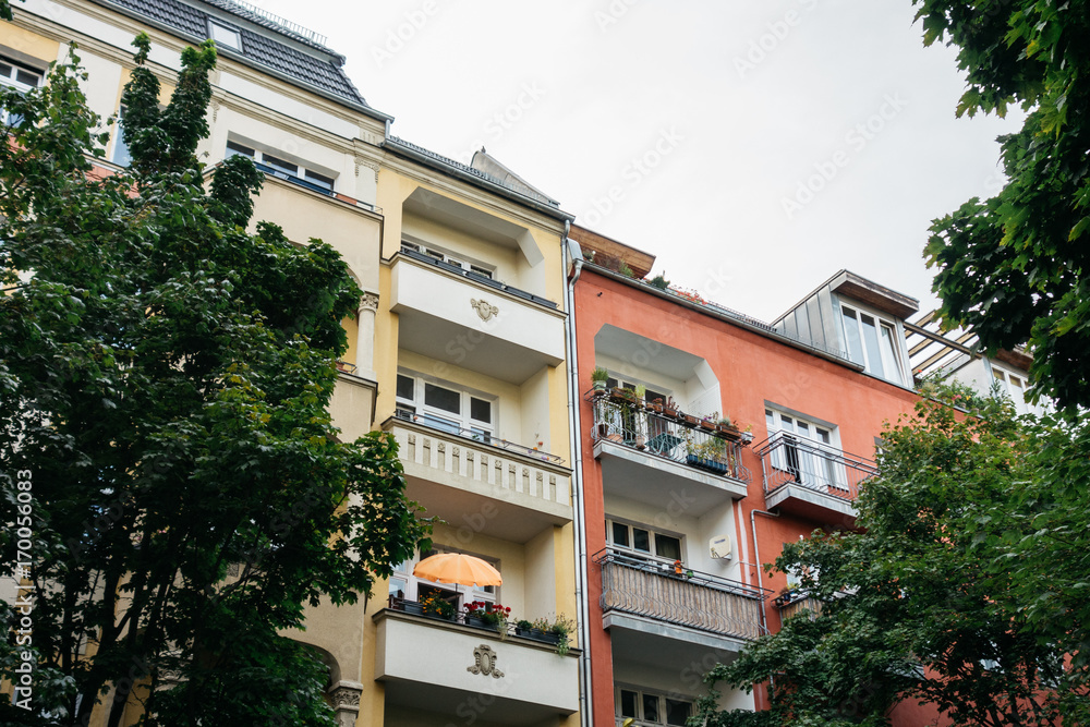 Fototapeta premium yellow and red houses in berlin framed by trees