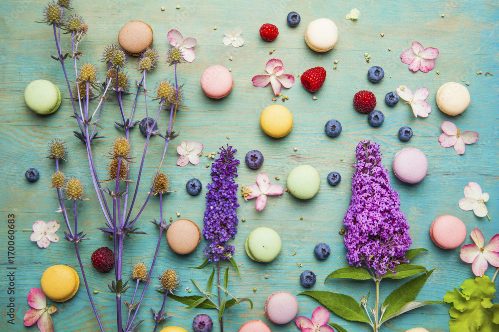 Obraz premium Variety of colorful french sweet dessert - les macarons with flowers and berries.