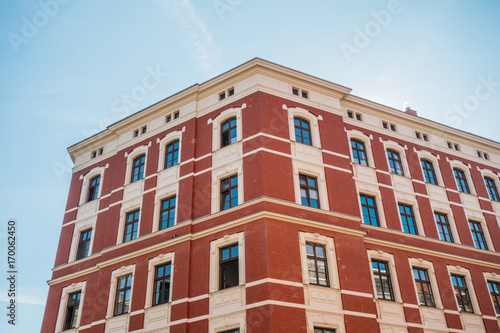 beautiful brick corner building with red facade and clean sky
