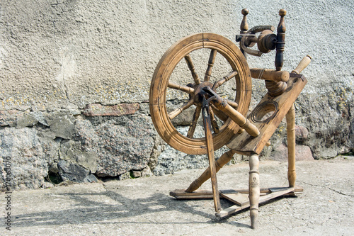 Beautiful old spinning wheel standing against a wall - horizontal photo