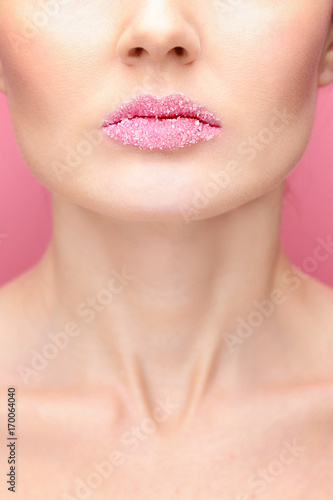 Beautiful young woman with sugary lips on color background