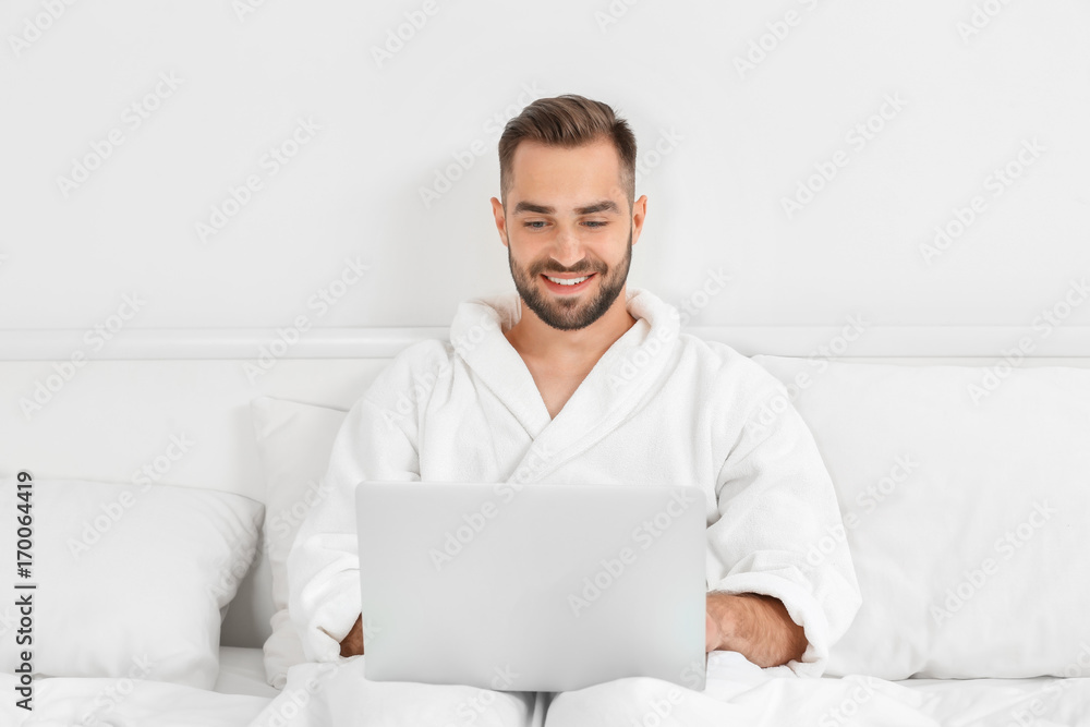 Young man using laptop in hotel room