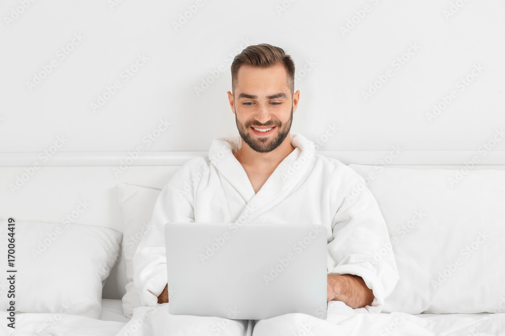 Young man using laptop in hotel room Young man using laptop in hotel room