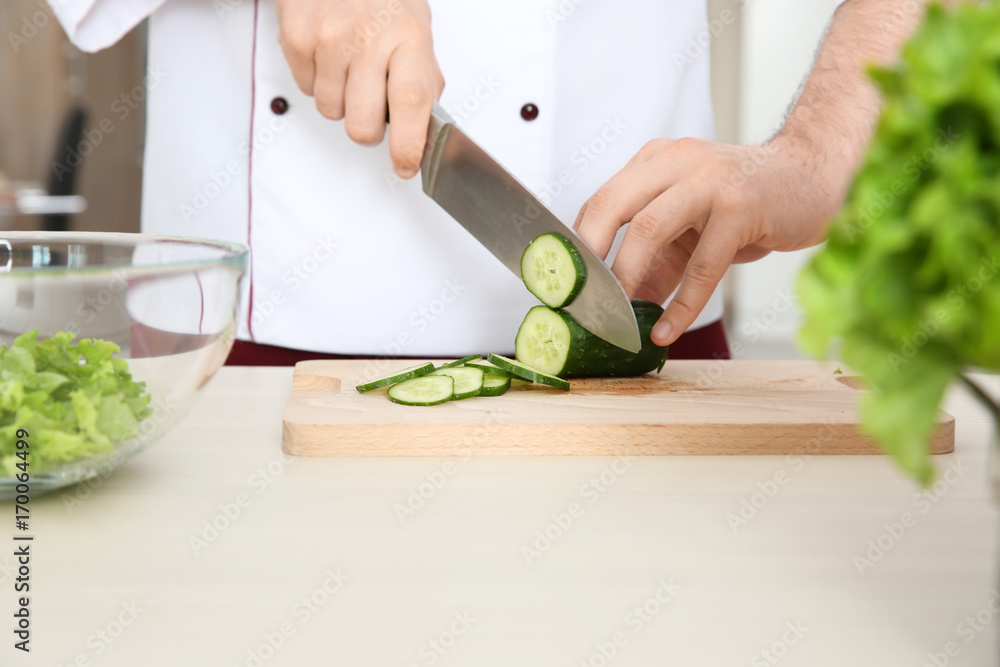 Chef slicing cucumbers on cutting board. Concept of cooking classes