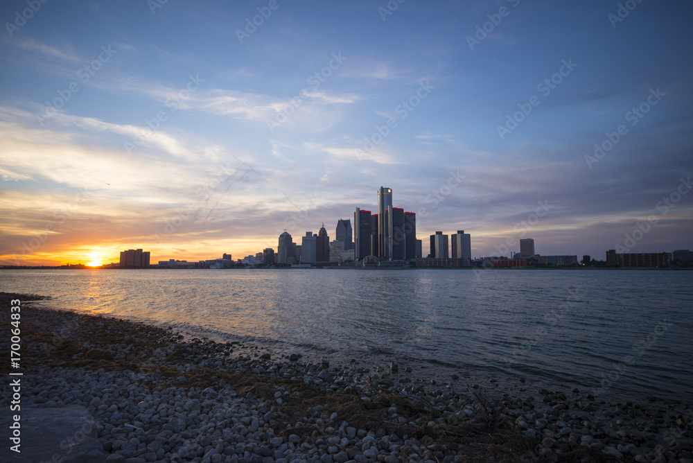 View of Detroit city skyline at sunset from the shore of the river