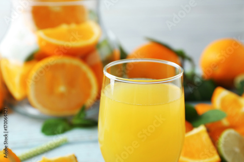 Glass with delicious orange juice on blurred background