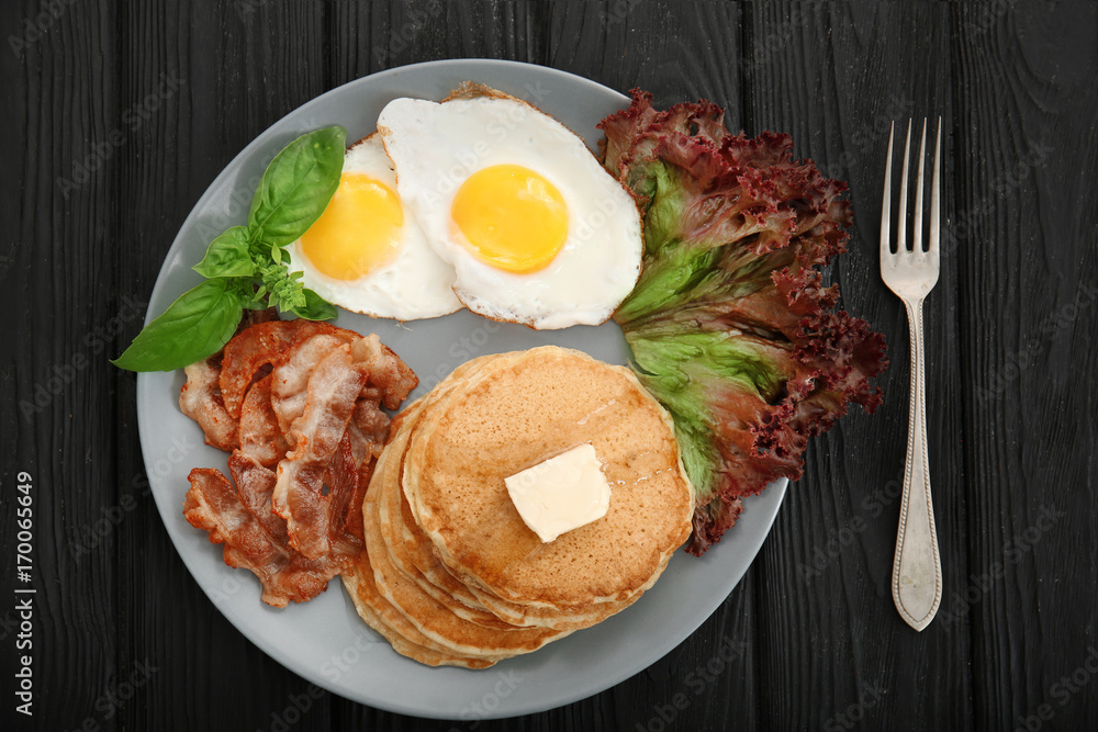 Tasty breakfast with fried eggs, pancakes and bacon on plate Tasty breakfast with fried eggs, pancakes and bacon on plate