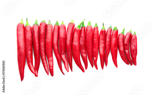 Horizontal row made of red chili peppers isolated on white