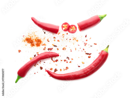 Whole and sliced red chili peppers pods with seeds isolated on white