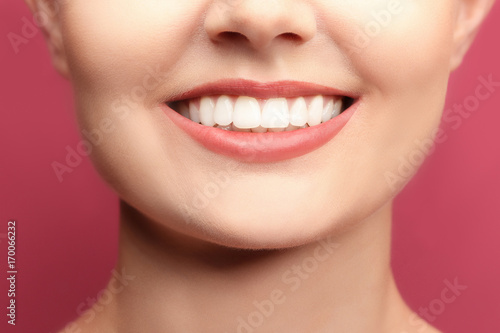 Young woman with healthy teeth on colour background  closeup