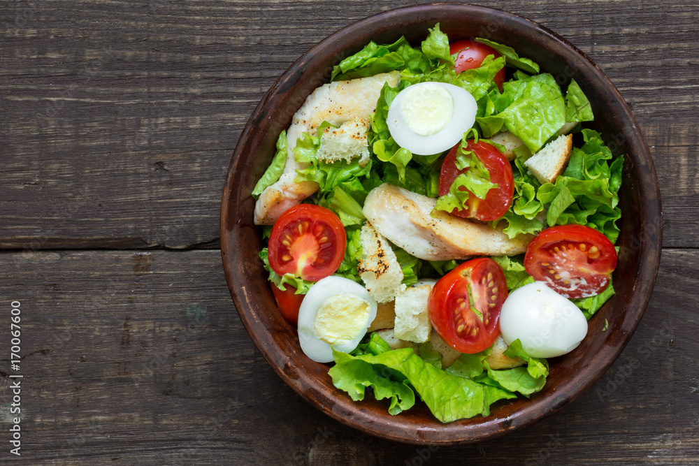 Caesar salad with croutons, quail eggs, cherry tomatoes and grilled chicken