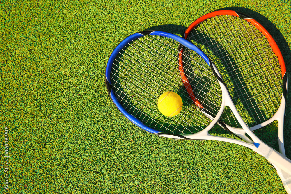 Tennis ball and rackets on court