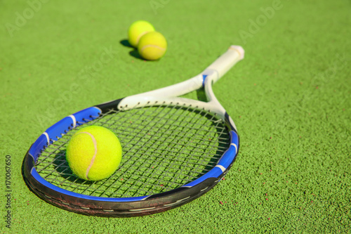 Tennis ball and racket on court © Africa Studio