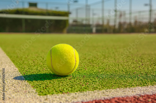 Tennis ball on modern court © Africa Studio