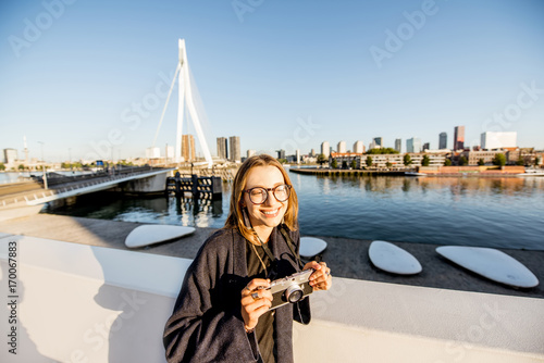 Portrait of a young woman tourist standing on the beautiful morning cityscape background in Rotterdam city