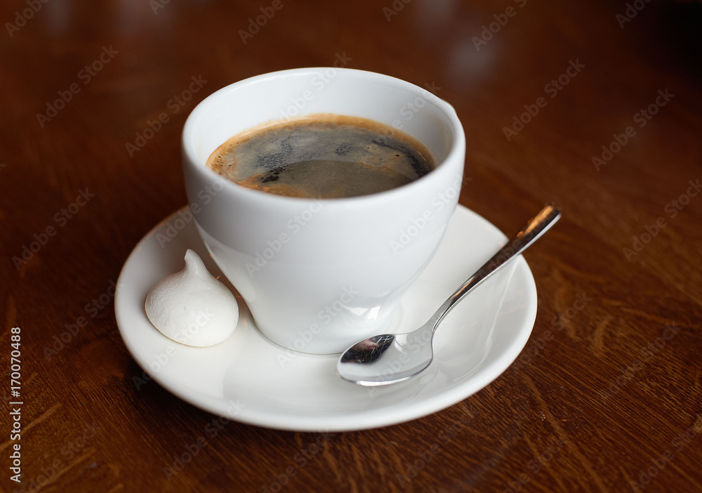 White cup with coffee, tea spoon and small cake White cup with coffee, tea spoon and small cake