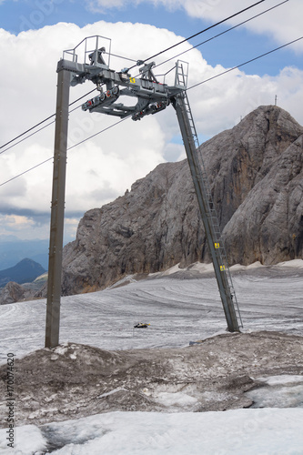 Snow groomer snowcat stands on Dachstein glacier near cable car photo