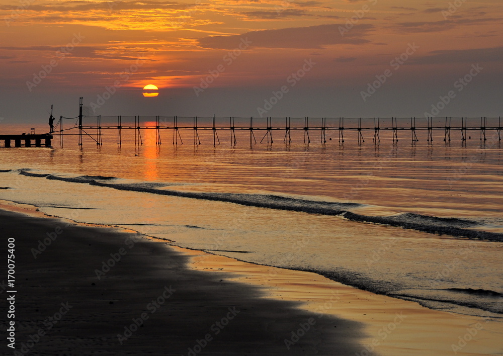 Fototapeta premium lever du soleil, mer, pêcheur