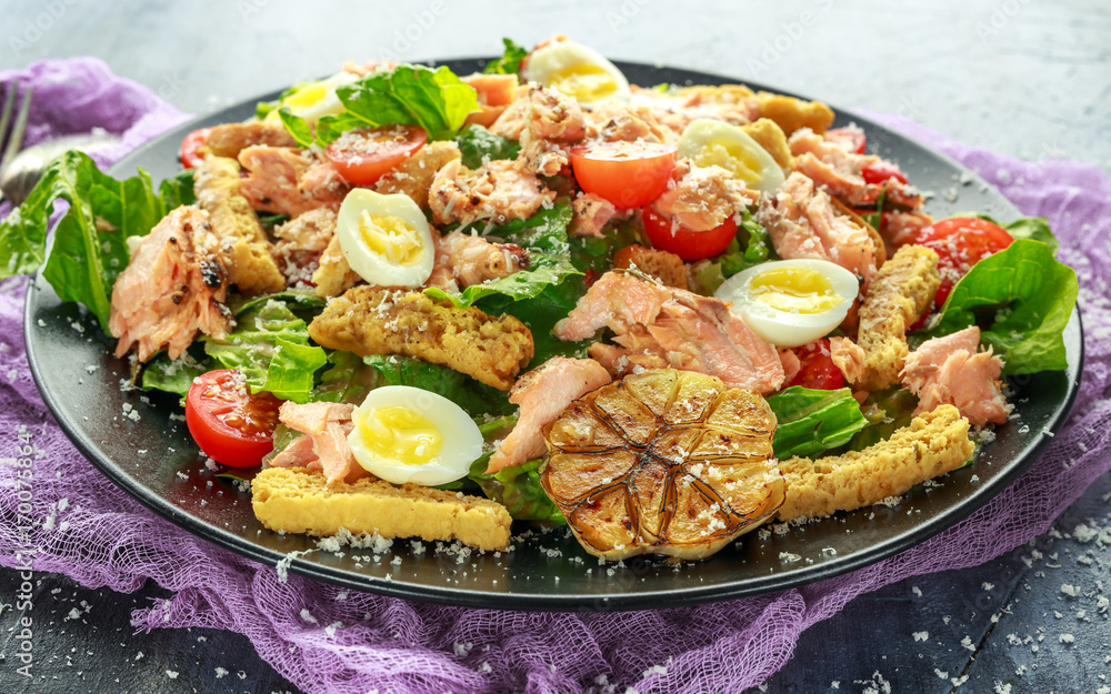Cesar salad with salmon, cherry tomatoes, garlic, crutons, romaine lettuce and parmesan. Cesar salad with salmon, cherry tomatoes, garlic, crutons, romaine lettuce and parmesan.
