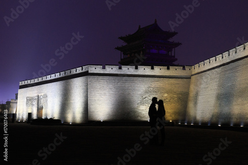 Silhouette of a couple kissing in front of the walls of Pingyao (UNESCO World Heritage site). A famous historic site in Pingyao, Shanxi, China.