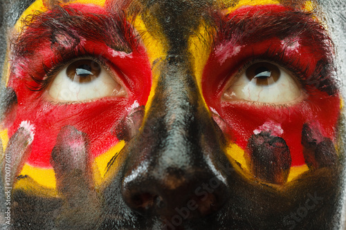 Fototapeta Naklejka Na Ścianę i Meble -  Eyes of Germany sports fan patriot. Painted country flag on man face.