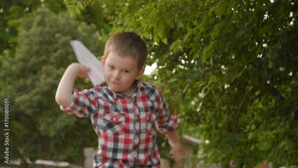 little boy launches a paper plane. slow motion little boy launches a paper plane. slow motion