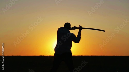 Portrait of a man with a sword at sunset, the path of a warrior. Samurai yakuza with a sword at sunset of the day.
