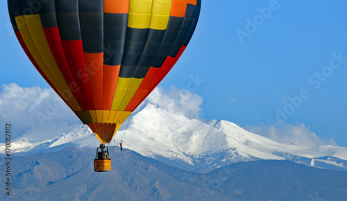 Hot air balloon with Colorado's Rocky Mountains in the background.