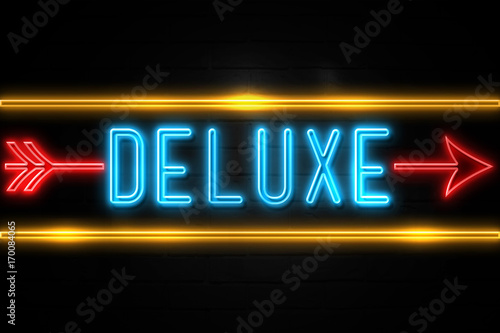 Deluxe - fluorescent Neon Sign on brickwall Front view
