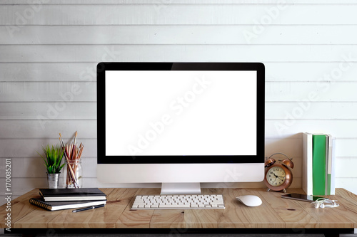 Stylish workspace with desktop computer, office supplies, houseplant and books at home or studio. Blank screen for graphics display montage.