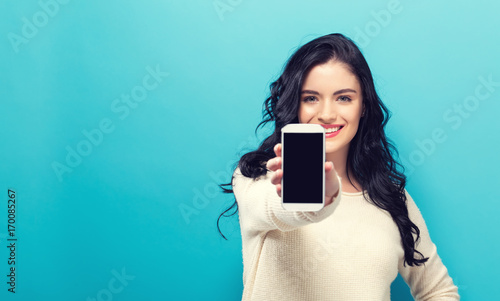 Young woman holding out a cellphone in her hand photo