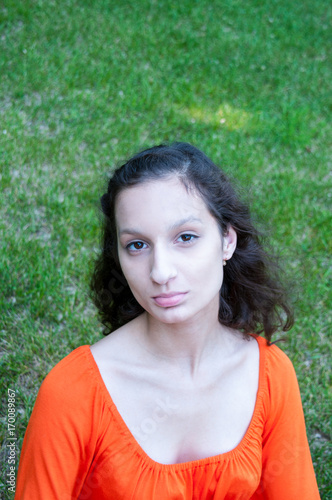 Portrait of a brunette girl in an orange dress