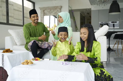 Family bonding over a traditional game of Five Stones during Hari Raya photo