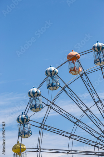 Ferris wheel in blue sky high up in the air