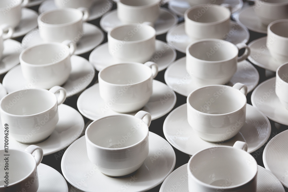 Large group of white coffee tea cups arranged in rows Large group of white coffee tea cups arranged in rows