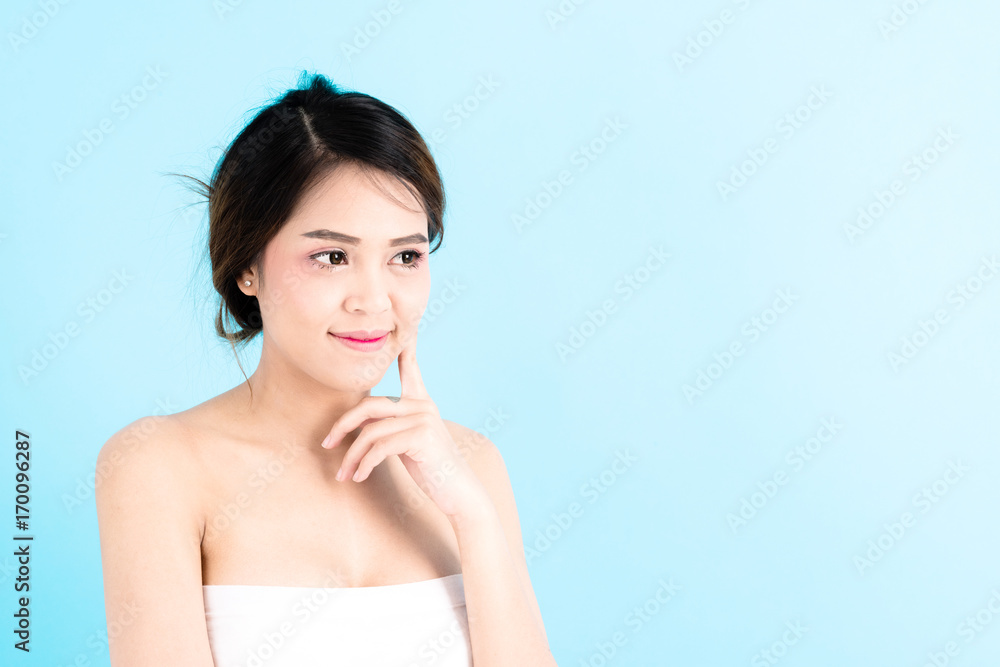 Asian young beautiful confidence woman smiling portrait touching her face over blue background. Asian young beautiful confidence woman smiling portrait touching her face over blue background.