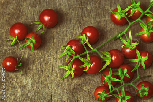 Fresh cherry tomato on rustic wood table. Top view cherry tomato for background or wallpaper. Prepare fresh cherry tomato for home cooking look so delicious. Top view with copy space in vintage tone.