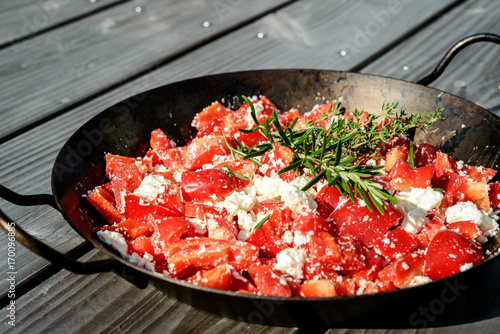 pepperand feta with rosemary and thyme in iron pan photo