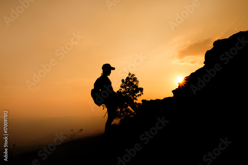 silhouette of a man hiker on the top of the hill